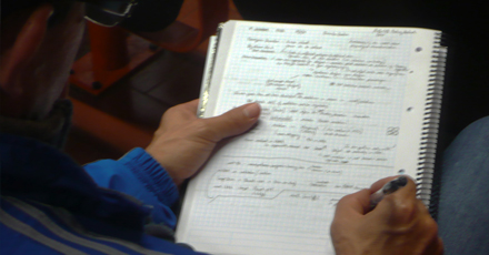 Aluna escreve notas num caderno
