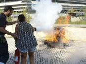 Bombeiro e participante a apagar um fogo com extintor no campus