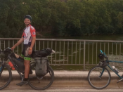 Luís Leitão posa para a foto em cima da sua BTT e em frente a um rio