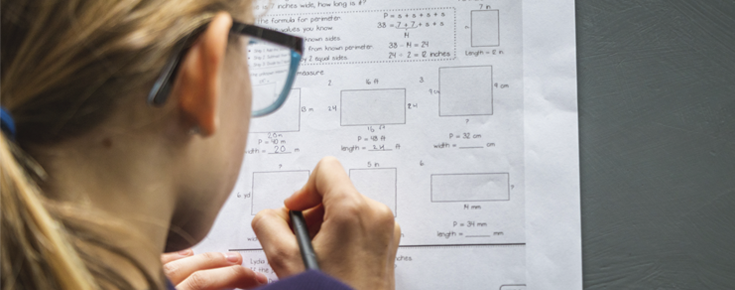 menina a escrever num papel com formulas matemáticas