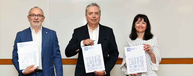 3 pessoas a mostrar uma capa da Faculdade com o protocolo dentro