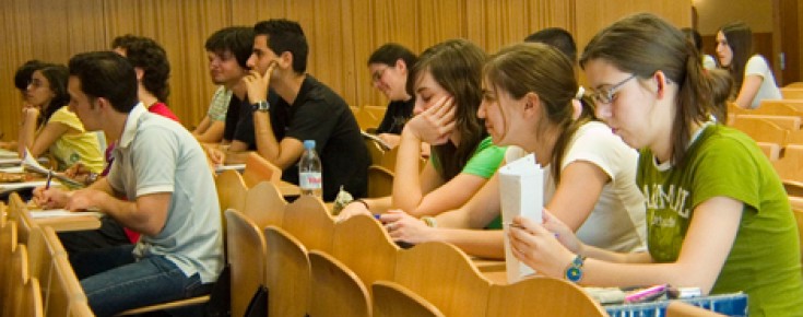 Sala de aula com alunos sentados e tomando notas