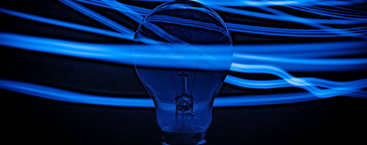Fotografia de lâmpada e feixes luminosos, em tons de azul